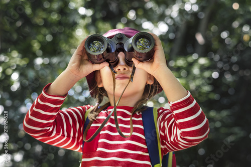 Cuadro en lienzo Little girl using binoculars in the forest