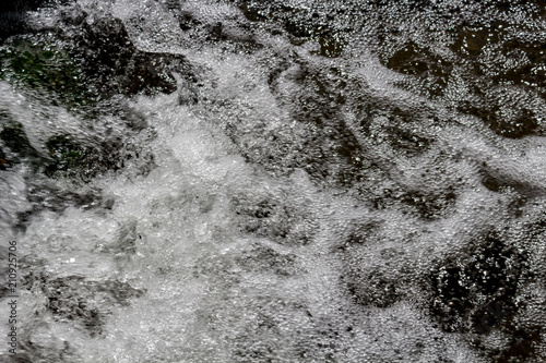 Splash and foam of falling water in a creek 