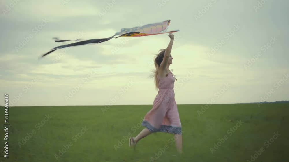 girl running around with a kite on the field. Freedom concept.