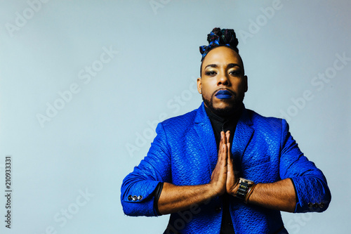 Canvas Print Portrait of a man in blue jacket and blue lips and hands together in prayer
