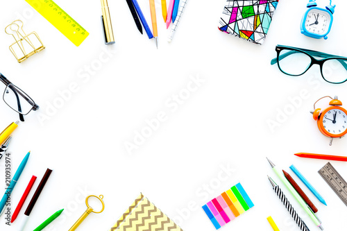 Education background, frame. School, student, office supplies. Stationery, glasses, alarm clock, notebook on white background top view copy space