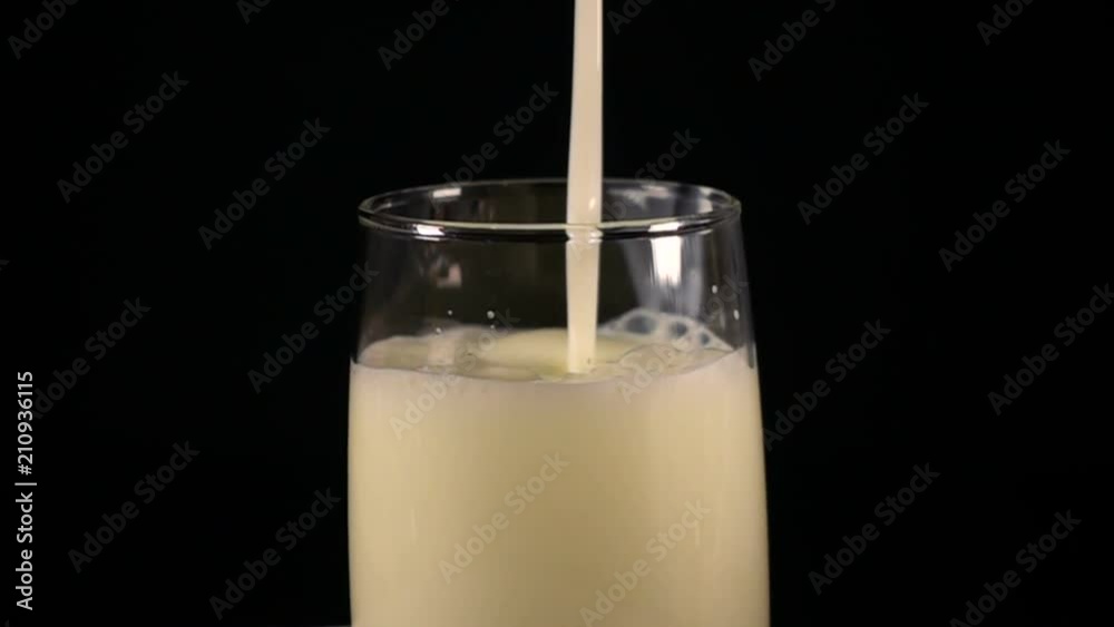 Pour milk into a glass. Slow motion. Pour milk into a glass. Slow motion.