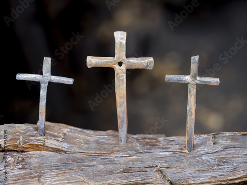 Hand crafted iron cross displayed in a blacksmith shop. Backgrounds in blur to set off its holy feeling.