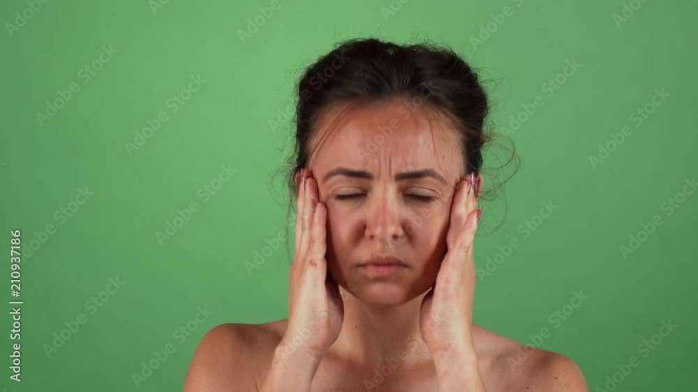 Young beautiful female looking nervous, rubbing her temples. Attractive woman having anxiety, posing green chromakey background. Stress, depression, worrying concept. Young beautiful female looking nervous, rubbing her temples. Attractive woman having anxiety, posing green chromakey background. Stress, depression, worrying concept.
