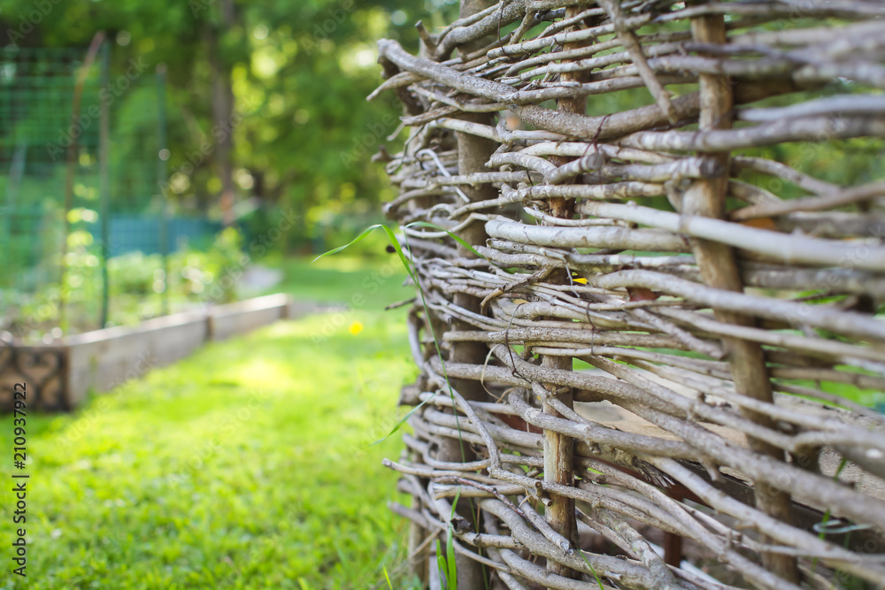 Fototapeta premium Wicker fence closeup, background, focus with shallow depth of field