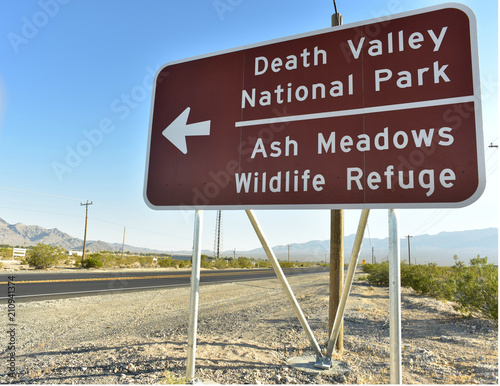 road sign in Pahrump, Nevada, USA along side of highway 160 pointing to the road to turn to go to Death Valley National Park and Ash Meadow Wildlife Refuge photo