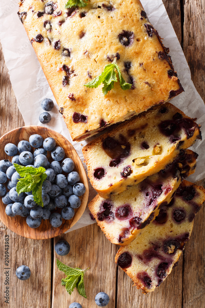 fresh blueberry loaf of bread muffin cake with mint closeup. vertical top view fresh blueberry loaf of bread muffin cake with mint closeup. vertical top view