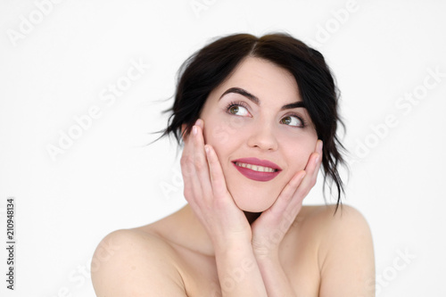 emotion face. happy smiling joyful jolly woman holding head in hands. young beautiful brunette girl portrait on white background.