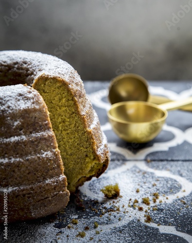 Matcha gugelhupf with icing sugar, cut into pieces photo