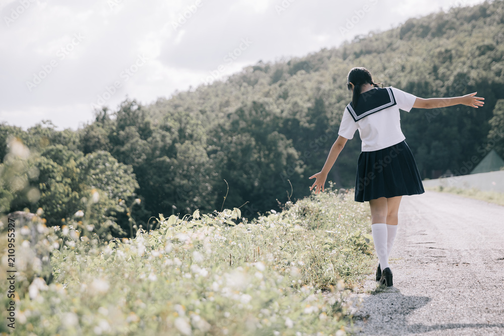Naklejka premium Portrait of asian japanese school girl costume looking at park outdoor film vintage style