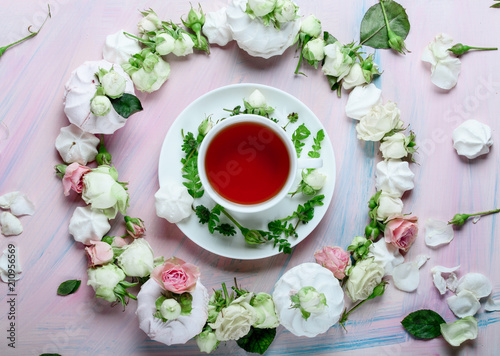 White cup of spring tea with rose petals