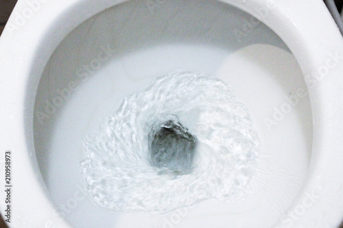 selective focus close up flushing toilet bowl for sanitary, Toilet, Flushing Water, close up, water flushing in toilet, A photo of a white ceramic toilet bowl in the process of washing it off. Ceramic