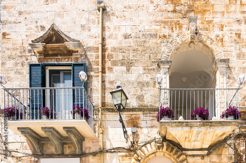 Lamp and balconies decorated with flowers in Cisternino, Apulia, Italy photo