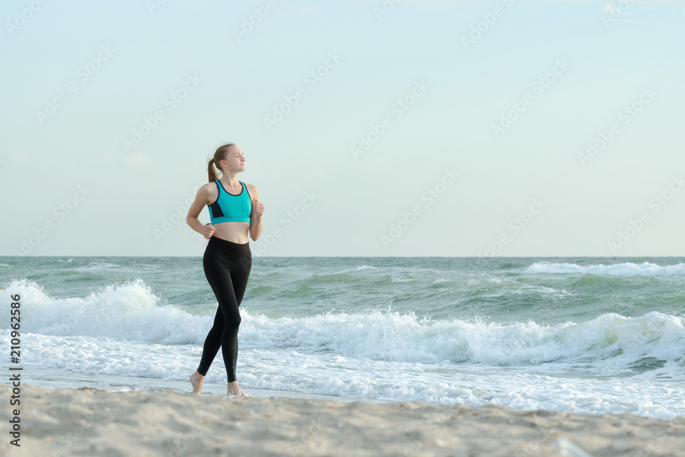 Girl in sportswear running along the surf line. Early morning. Girl in sportswear running along the surf line. Early morning.
