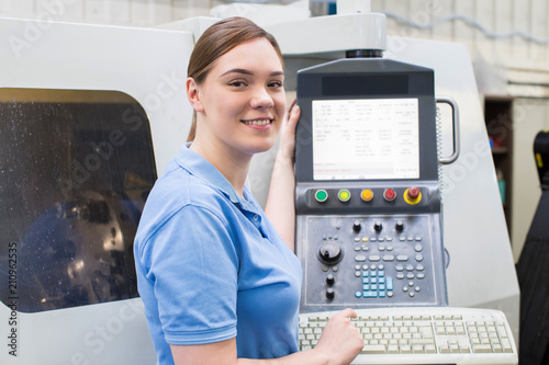Bilde på lerret Portrait Of Female Apprentice Engineer Operating CNC Machine In Factory