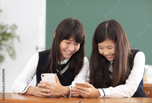 teenager girl student watching the smart phone in classroom
