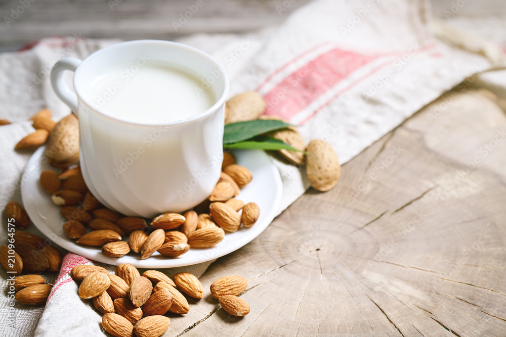 Almond and almond milk on a wooden table in the summer garden. Useful food. Almond and almond milk on a wooden table in the summer garden. Useful food.