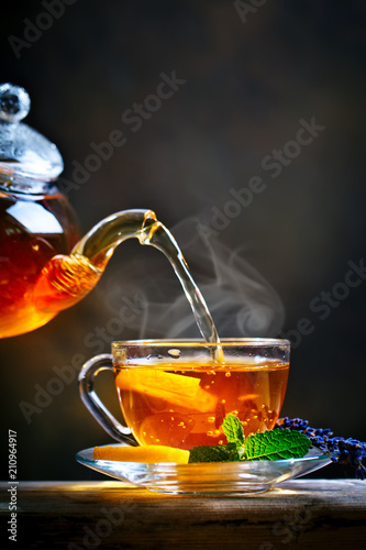 Process brewing tea,tea ceremony. Cup of freshly brewed black tea,warm soft light.