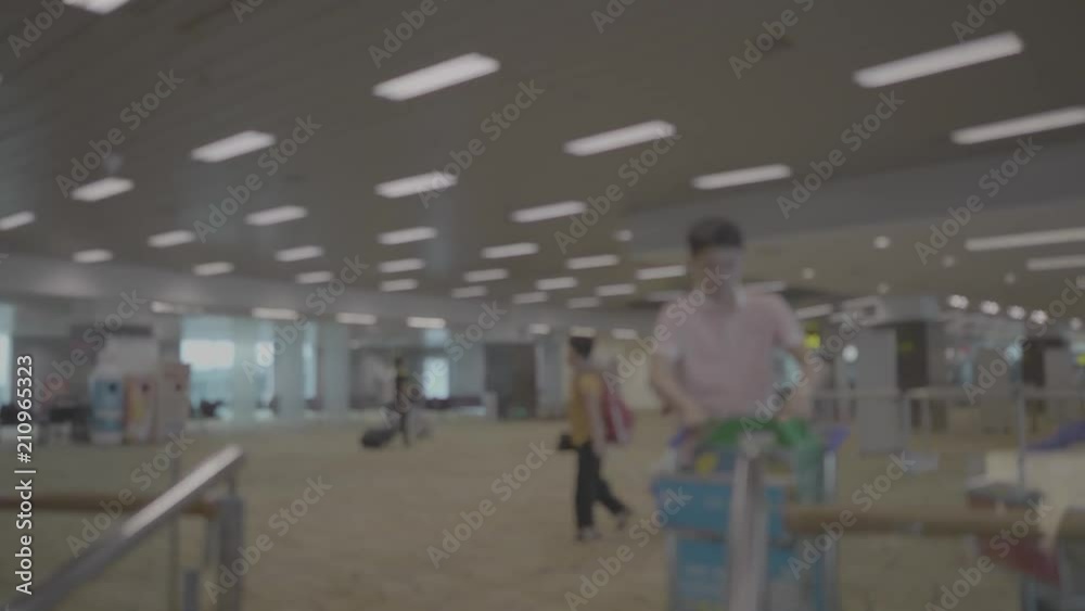 Silhouette of passengers in the airport carrying bags and luggage trolleys Silhouette of passengers in the airport carrying bags and luggage trolleys