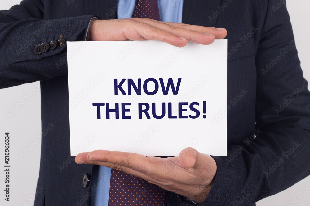 Man showing paper with KNOW THE RULES! text Man showing paper with KNOW THE RULES! text