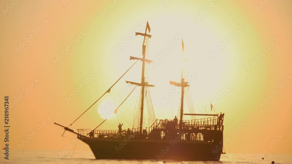 Beautiful sunset. The ship sails the waves during sunset. Sea walk on a sea ship. Silhouette of the ship at sunset. Beautiful sunset. The ship sails the waves during sunset. Sea walk on a sea ship. Silhouette of the ship at sunset.