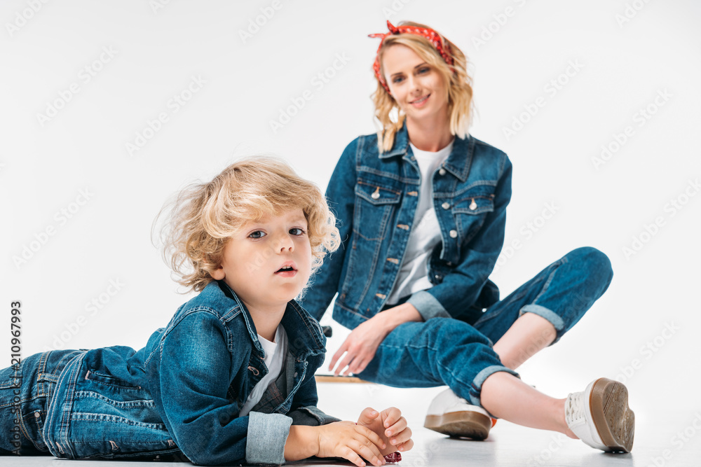 mother sitting on skateboard and looking at son on white mother sitting on skateboard and looking at son on white