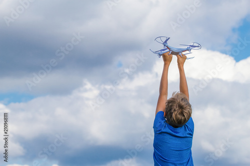 Child holding drone outdoors at summer day