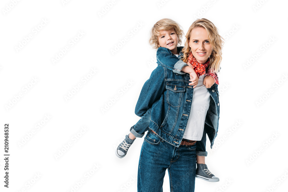 smiling mother having fun and giving piggyback to son isolated on white smiling mother having fun and giving piggyback to son isolated on white