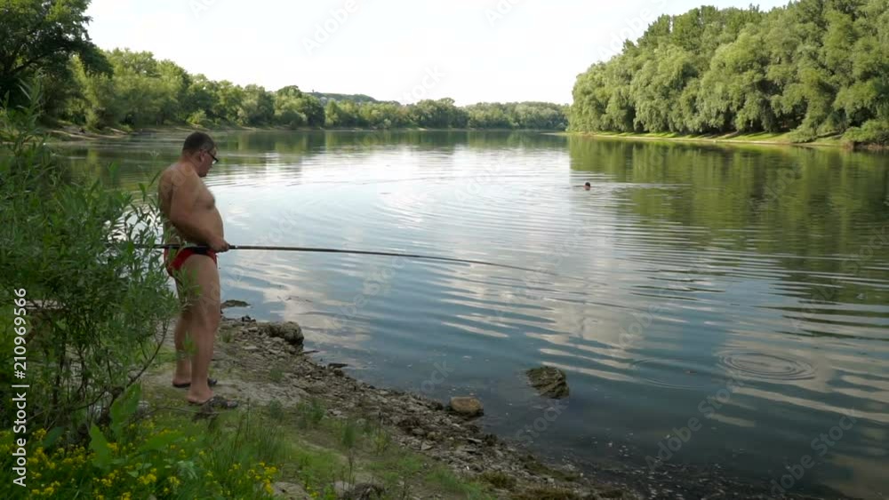 Fishing in river.A fisherman with a fishing rod on the river bank. Fishing in river.A fisherman with a fishing rod on the river bank.