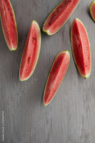 flat lay with arranged watermelon slices on grey wooden surface