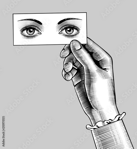 Female hand holding a card with eyes drawing
