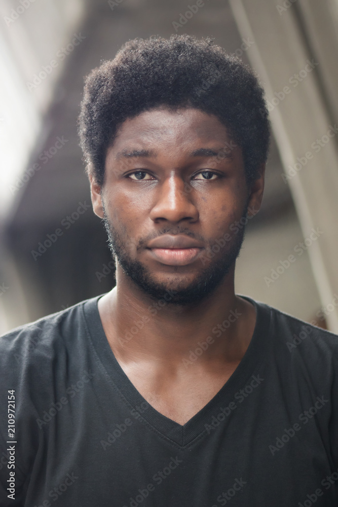 portrait of 20s African man; headshot portrait of young adult black skin african man; west African young adult man model