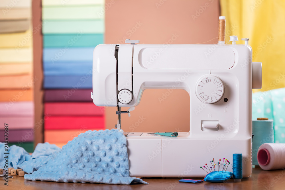 Sewing machine and cloth in work, sewing supplies on table