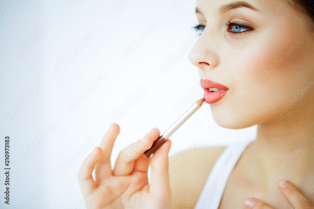 Beauty and Care. Portrait of a Young Woman with a Beautiful Skin. Beautiful Lips. Girl Holding Lipstick in her Hands. Woman with Beautiful Blue Eyes. Makeup. Care for the Lips Beauty and Care. Portrait of a Young Woman with a Beautiful Skin. Beautiful Lips. Girl Holding Lipstick in her Hands. Woman with Beautiful Blue Eyes. Makeup. Care for the Lips