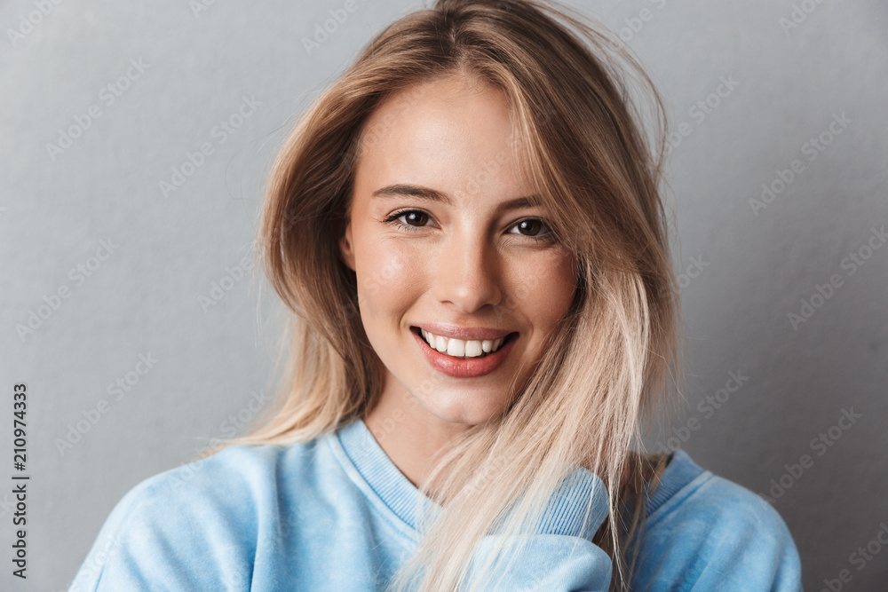 Close up of a smiling young girl in blue sweatshirt - obrazy, fototapety, plakaty 