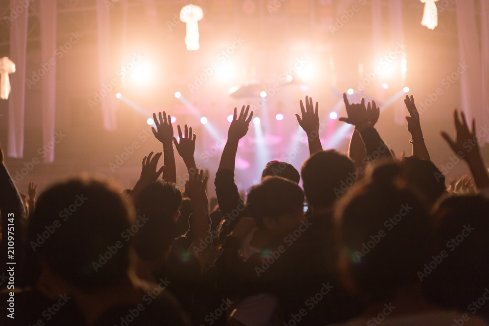 Fototapeta premium Crowd at concert and blurred stage lights, noise added later in post processing for vintage usage