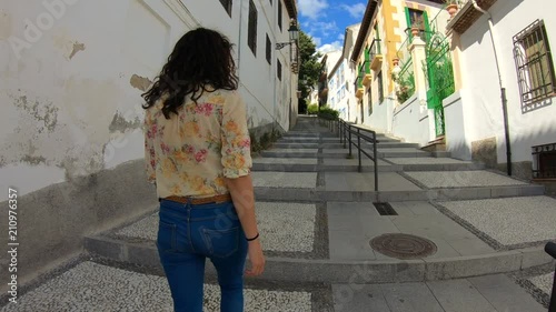 Tourist woman exploring European town. Beautiful girl walking through street travelling enjoying summer vacation travel adventure Granada, Alhambra