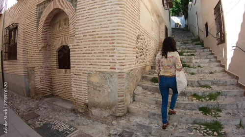 Tourist woman exploring Granada. Beautiful girl walking through street travelling enjoying summer vacation travel adventure Alhambra