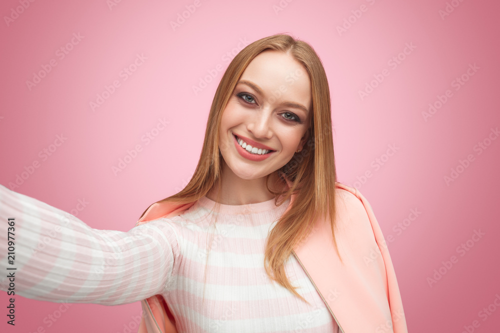 Smiling blond woman taking selfie Smiling blond woman taking selfie