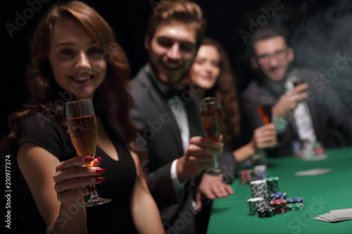 fashion woman with glasses of wine,sitting at a table in a casino