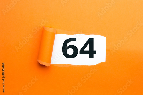 Zahl vierundsechzig - 64 verdeckt unter aufgerissenem orangen Papier photo