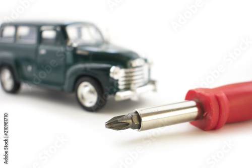 Car technician hands checking the air flow sensor with screwdriver in auto repair service.