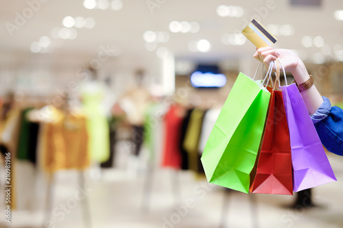 Young beautiful girl with shopping bags and credit card doing shopping in the mall