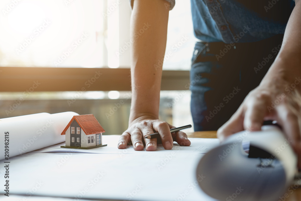 Fototapeta premium Construction engineering. Close up of engineers hands working on table at site office