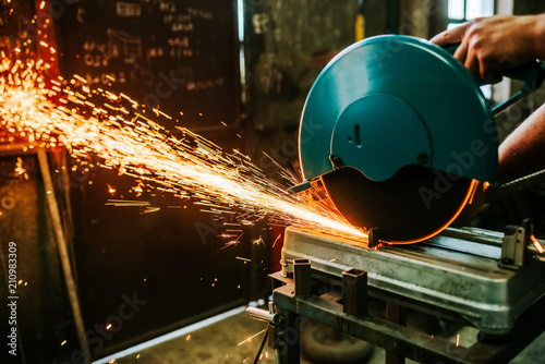 Sparks flying while cutting metal with mitre saw. photo