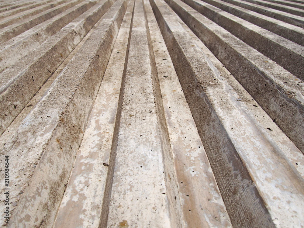 close up of cast concrete with vertical ribbed texture with a converging view in sunlight and shadow close up of cast concrete with vertical ribbed texture with a converging view in sunlight and shadow