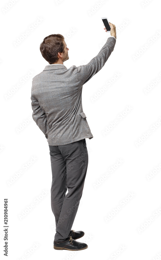 Back view of a businessman in a suit making a selfie. Back view of a businessman in a suit making a selfie.