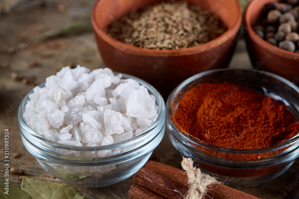 Spices in ceramic bowls on the top of wooden barrel, close-up, selective focus, vertical. Spices in ceramic bowls on the top of wooden barrel, close-up, selective focus, vertical.