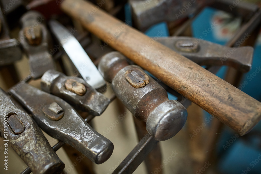 Working metal tools in blacksmith's workshop, close-up, selective focus, nobody Working metal tools in blacksmith's workshop, close-up, selective focus, nobody