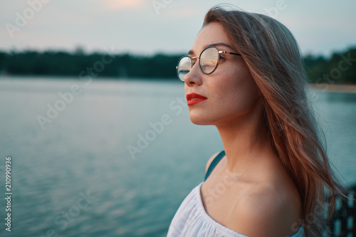 Attractive girl wearing glasses on park lake view